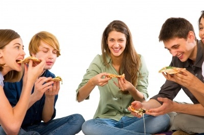 Smiling Teenagers Eating Pizza